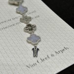 Van Cleef & Arpels watch with silver dial, diamond-set clover motif, and white mother-of-pearl.